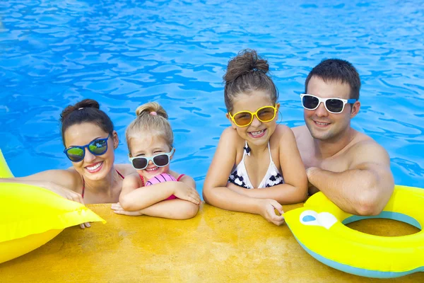 Šťastná rodina s dvěma dětmi, zábava v bazénu — Stock fotografie