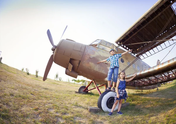 Kleiner Junge und kleines Mädchen Pilot in der Nähe des Retro-Flugzeugs — Stockfoto