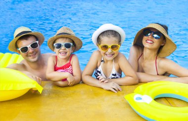 Yüzme havuzunda eğleniyor iki çocuklu mutlu aile