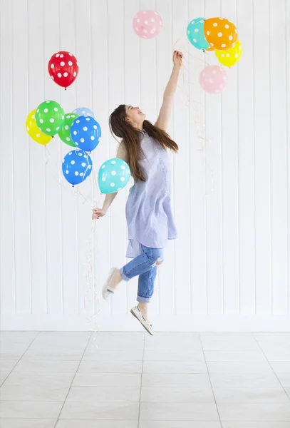 Счастливая девочка-подросток с гелиевыми воздушными шарами — стоковое фото