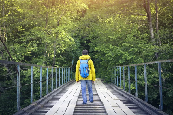 Toeristische man lopen houten brug — Stockfoto