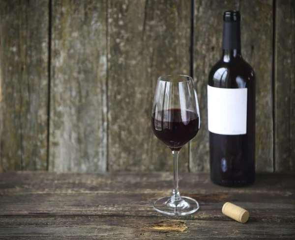 Butelka wina, przy lampce czerwonego wina — Zdjęcie stockowe