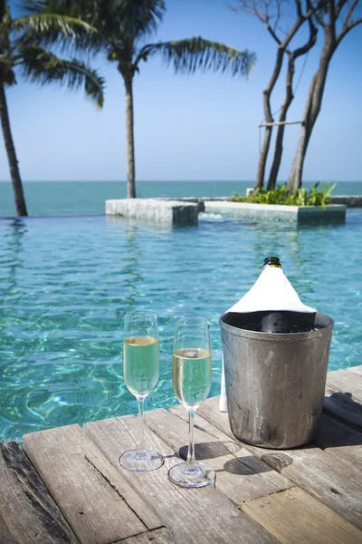 Champagne bottle in ice bucket and champagne glasses — Stock Photo, Image