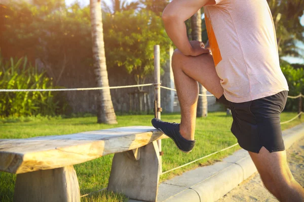 Jonge fitness man loper stretching benen voor run — Stockfoto