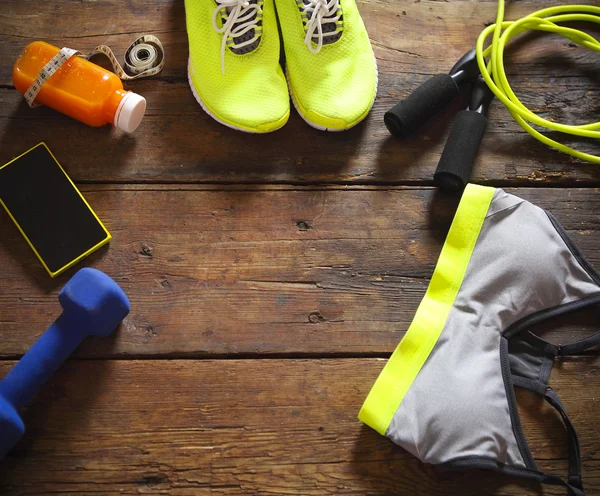 Equipamiento deportivo femenino sobre fondo de madera — Foto de Stock