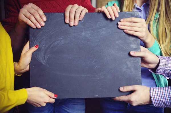 Groupe de jeunes partenaires commerciaux avec panneau noir vierge — Photo