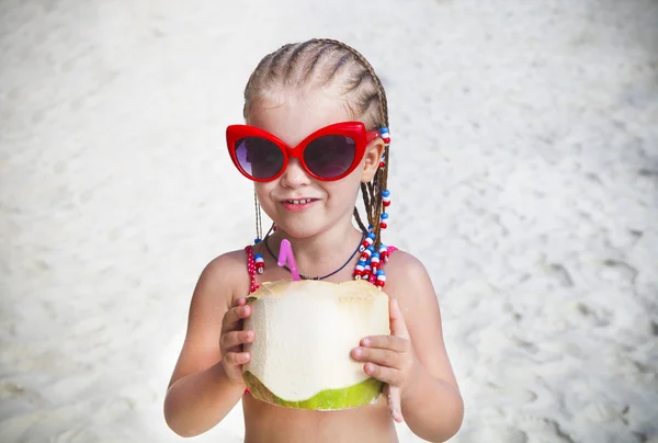 かわいい小さな女の子飲むココナッツ カクテル熱帯のビーチに — ストック写真