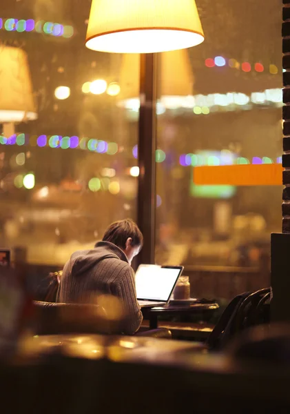 Uomo sfocato con computer portatile sullo sfondo del caffè — Foto Stock