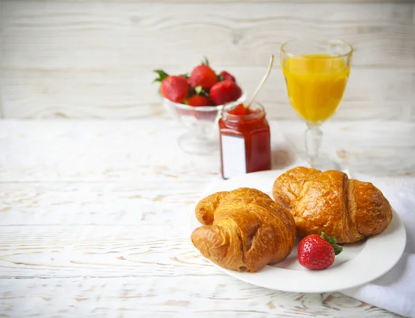 Två läckra croissanter på plattan och jordgubbssylt — Stockfoto