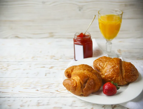 Dois saborosos croissants no prato e geléia de morango — Fotografia de Stock