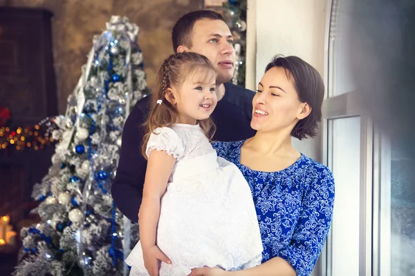 Família feliz com filhinha na árvore de Natal — Fotografia de Stock