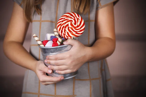 Bucket with colorful candies in the hands of little girl — Stock Photo, Image