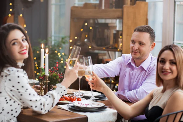 Cheerful Young Friends Sitting Festive Table Clinking Glasses Champagne While — Stock Photo, Image