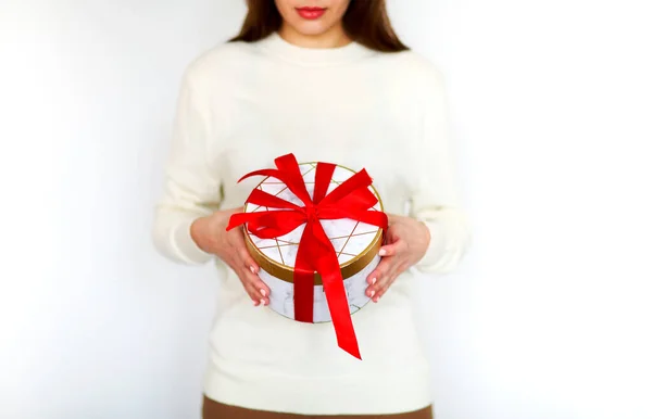 認識できない女の子でホワイトセーター保持ラウンドプレゼントボックス縛らとともに明るい赤リボン中休日お祝い — ストック写真