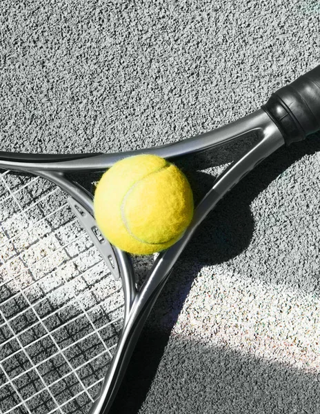 Close up of tennis racquet and ball on the clay tennis court