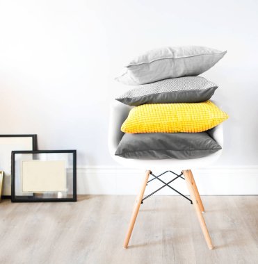 Moda renklerinde yastıkların olduğu bir iç mekânda sandalye. Konforlu ve modaya uygun iç mekan kavramı 