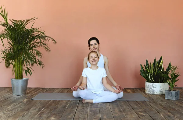 Gülümseyen Genç Kadın Küçük Kız Rahat Oturma Odasında Yoga Yapıyorlar — Stok fotoğraf