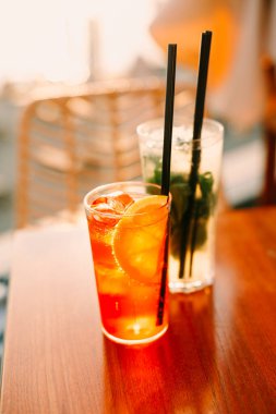 Bardakların yüksek açılı ve soğuk kokteyller ve pipetler yaz günü barda masaya konur.