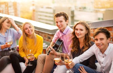 Arkadaşlarıyla buluşurken içki içen mutlu adam ve kadın.