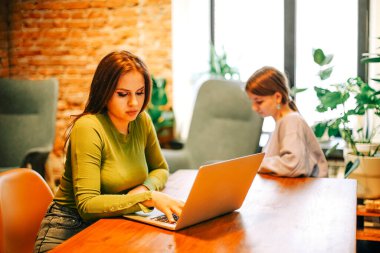 Kafede dizüstü bilgisayar kullanan neşeli bir serbest yazar.