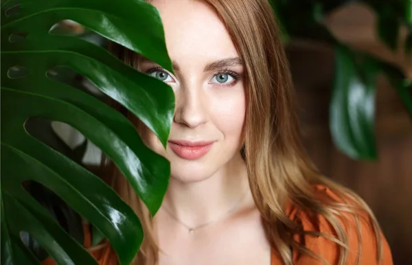 Mujer Tranquila Pie Detrás Hoja Monstera Mirando Cámara Fondo Borroso — Foto de Stock