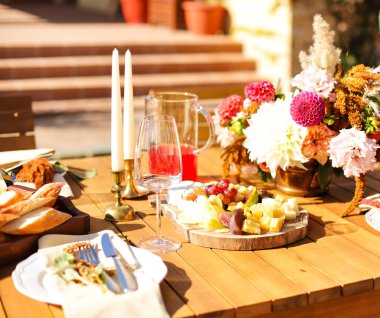 Boş şarap kadehleri güneşli yaz gününde ziyafet masasında meyvelerle birlikte tahtanın yanına konur.