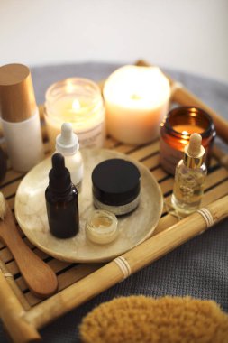 Aromaterapi mumlarından ve kaplıca salonundaki ahşap tepsiye yerleştirilmiş çeşitli cilt ürünlerinden.
