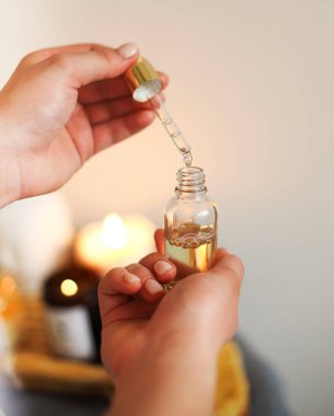 Masöz, masaj yağlı pipetini kuaförde çeşitli spa malzemeleriyle tepsiye koyar.