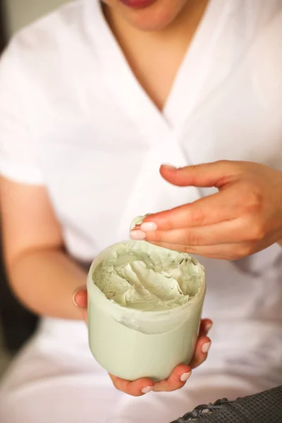 美容室で緑のクリームを栄養の瓶と作物匿名の女性美容師の高い角度 — ストック写真