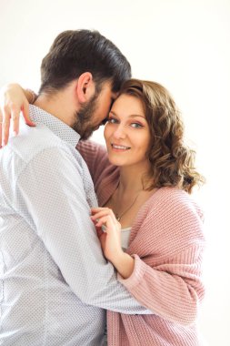 Memlekette beyaz arka planda kucaklaşan içerik seven çiftin yan görünümü