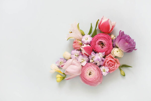 Top view of organic fresh flowers arranged in beautiful compositions on light blue background