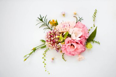 Açık mavi arkaplanda güzel kompozisyonlarda sıralanmış organik taze çiçeklerin üst görüntüsü