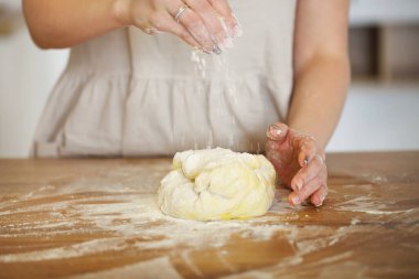 Mutfakta yemek pişirirken hamuru olan tanınmayan bir ev hanımı.