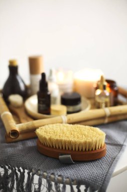 Evdeki masaya çeşitli cilt bakım ürünleri konmuş mumlar ve kaplar yakıyor.