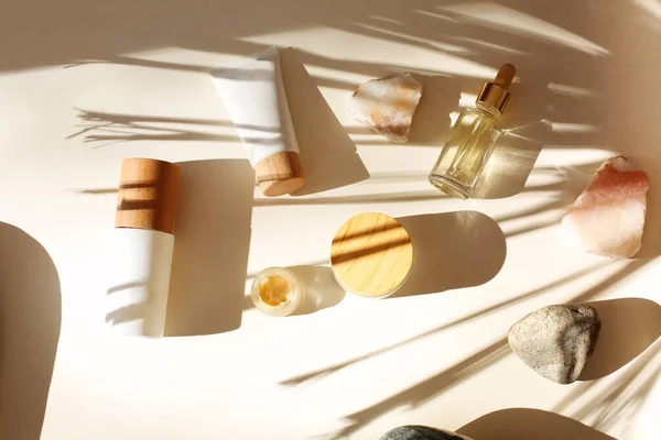 Draufsicht Auf Flaschen Verschiedener Kosmetikprodukte Inmitten Von Steinen Mit Palmenschatten — Stockfoto