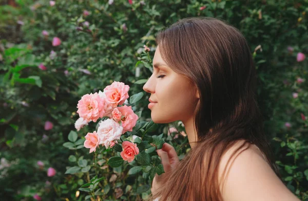 时尚户外照片 美丽的性感女子 乌黑的头发 摆设在玫瑰丛中的花园 — 图库照片