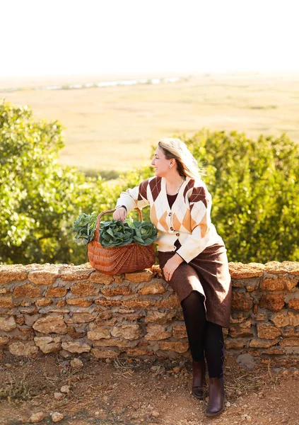 Female Leaning Wicker Basket Fresh Cabbage While Resting Brick Fence — Stockfoto