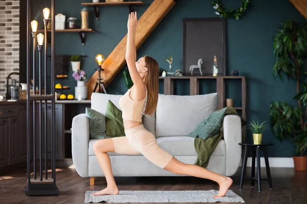 Spor Giyimli Sıska Bir Kadın Evde Kanepede Yoga Yaparken Eğiliyor — Stok fotoğraf