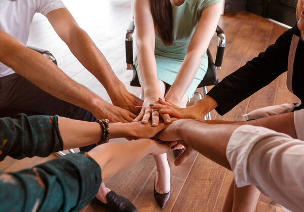 Business people folding their hands together. Team and sucsess concept