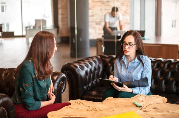 Elegant businesswoman interviewing female candidate while having meeting in modern office sitting opposite