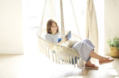 Bütün vücudu, hafta sonu güneşli odada sallanan sandalyede dinlenip kitap okuyan genç bir bayandan memnundu.