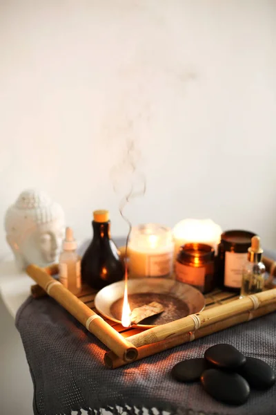 芳香療法用品の近くの竹盆の上で白い背景に燃える芳香香棒 — ストック写真