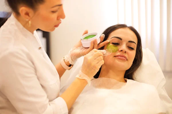 Professionele Schoonheidsspecialiste Zetten Groene Vlekken Onderoog Gebied Van Kalme Vrouwelijke — Stockfoto