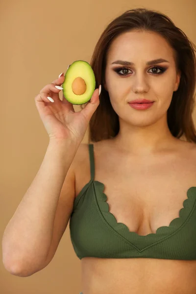 Joven Hembra Mirando Cámara Demostrando Mitades Aguacate Maduro Sobre Fondo —  Fotos de Stock