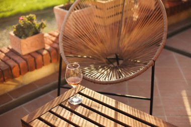 Güneşli bir yaz gününde bahçede tuğla bariyerlere konulan yüksek açılı şarap kadehi.