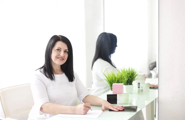 Hermosa Joven Sonriente Doctora Sentada Escritorio Escribiendo — Foto de Stock