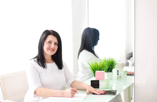 Bonito Jovem Sorridente Médico Feminino Sentado Mesa Escrevendo Imagens De Bancos De Imagens