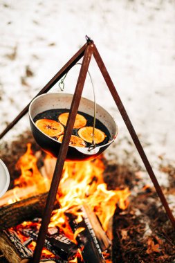 Geleneksel sıcak şaraptan portakal dilimleriyle kırsal kesimlerde yanan odunların üzerinde hazırlanıyor.
