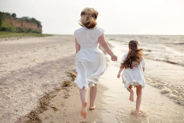 Полное Тело Веселой Женщины Маленькой Дочерью Белом Платье Бегущей Пляжу — стоковое фото
