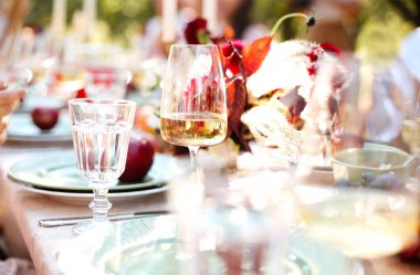 Etkinlik sırasında sofra masasının üzerine yerleştirilmiş taze çiçeklerin ve yanan mumların yumuşak odağı